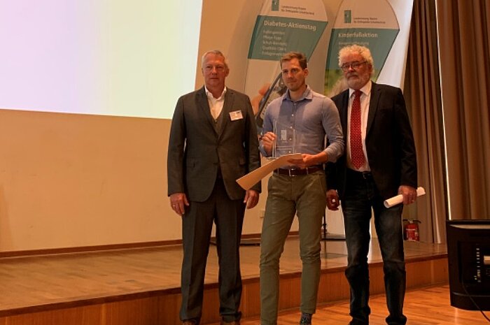 Martin Kreitmayr bekommt den Ehrenpreis der Landesinnung in Bayern für Orthopädie-Schuhtechnik 2019 für seine besonderen Leistungen von Innungsmeister Magnus Fischer und Prof. Henning Wetz überreicht. 